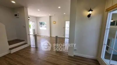 Spacious modern living room with wooden flooring and ample natural light