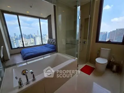 Luxurious bedroom with city view and modern en-suite bathroom featuring a bathtub.