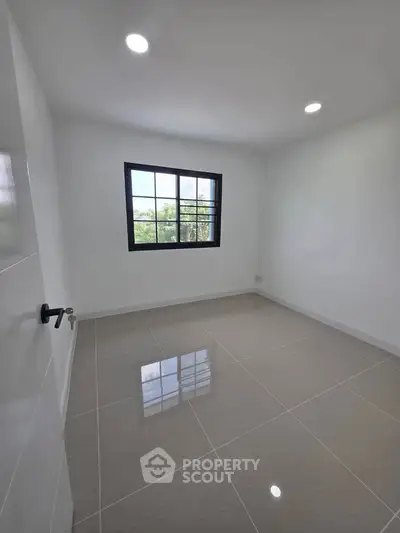 Bright empty room with glossy tiled floor and large window, perfect for customization.