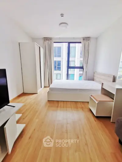 Bright modern bedroom with large window and minimalist furniture