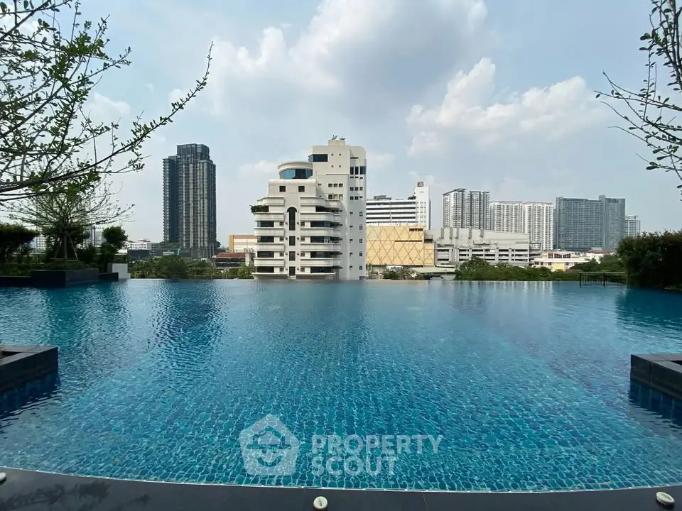 Luxurious rooftop infinity pool with stunning city skyline view, perfect for urban living enthusiasts.