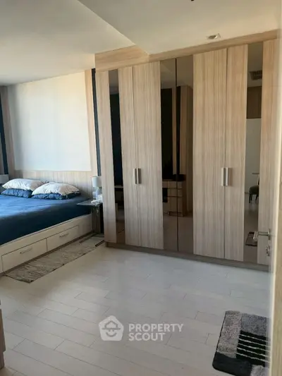 Modern bedroom with sleek wooden wardrobe and cozy bed