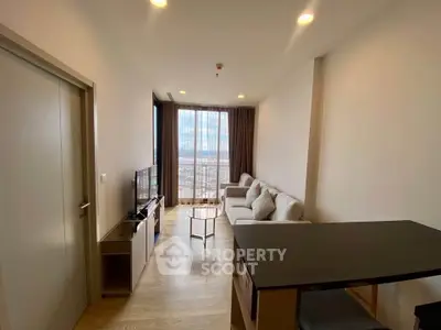 Modern living room with large window and city view, featuring cozy seating and sleek decor.