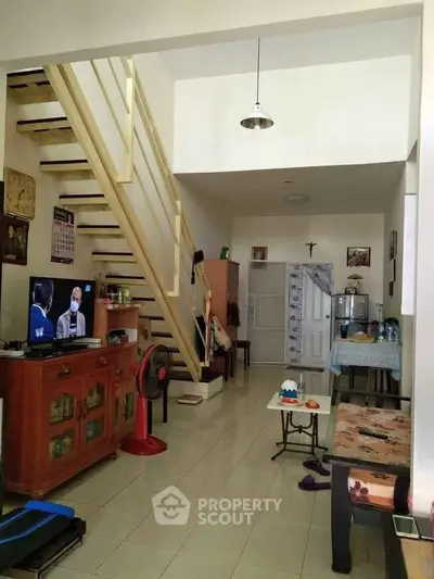 Cozy living room with staircase and dining area in a compact home