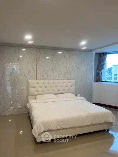 Luxurious bedroom with marble accent wall and city view