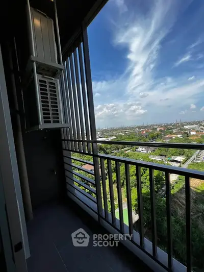 Stunning high-rise balcony with panoramic city views and clear blue skies.