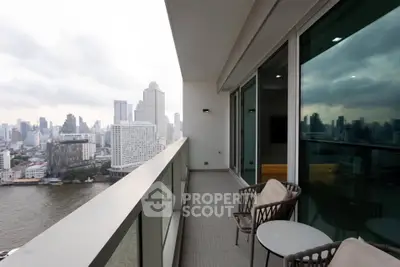 Stunning city and river view from a modern high-rise balcony with elegant seating.