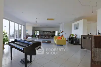 Spacious open-plan living room with modern decor and large windows