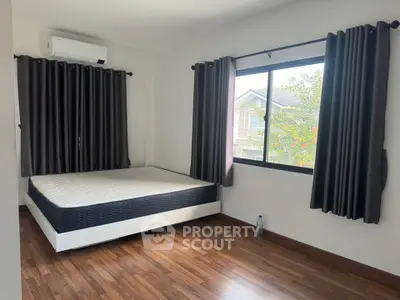 Spacious bedroom with large window and modern design in a cozy home