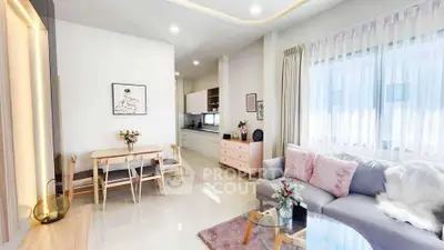 Modern living room with open kitchen, cozy seating, and elegant decor