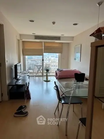 Modern living room with balcony view, featuring sleek furniture and natural light.