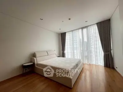 Spacious modern bedroom with large windows and elegant curtains