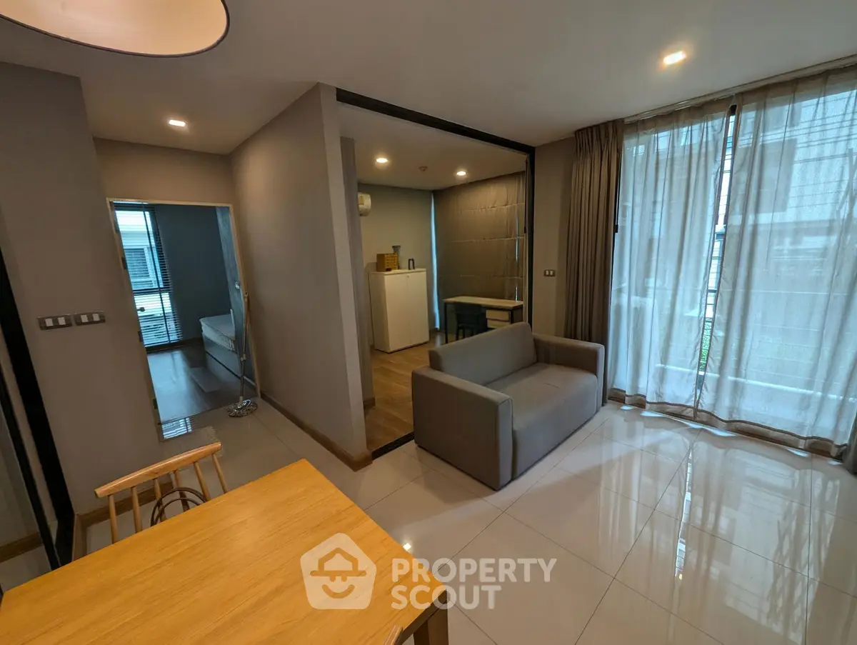 Modern open-plan living room with sleek furniture and large windows for natural light.