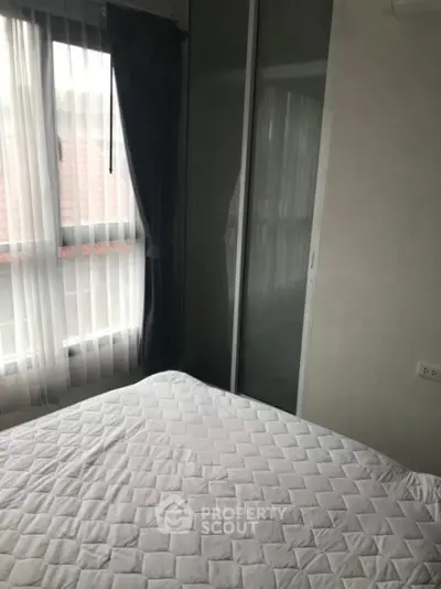 Cozy bedroom with large window and modern closet in a serene setting.