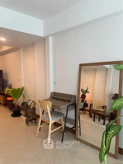 Stylish living room with modern decor and large mirror enhancing space.