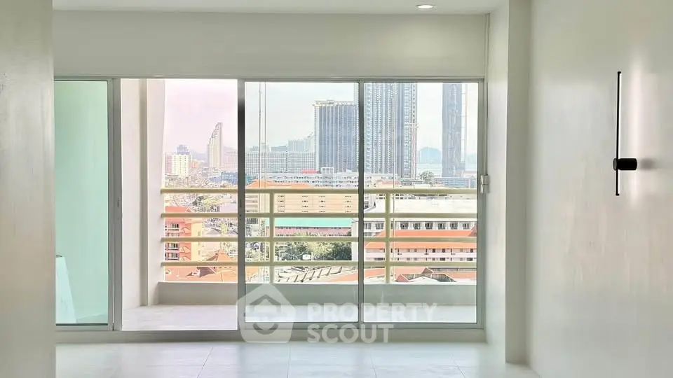 Modern apartment with large windows offering stunning city views and a spacious balcony.