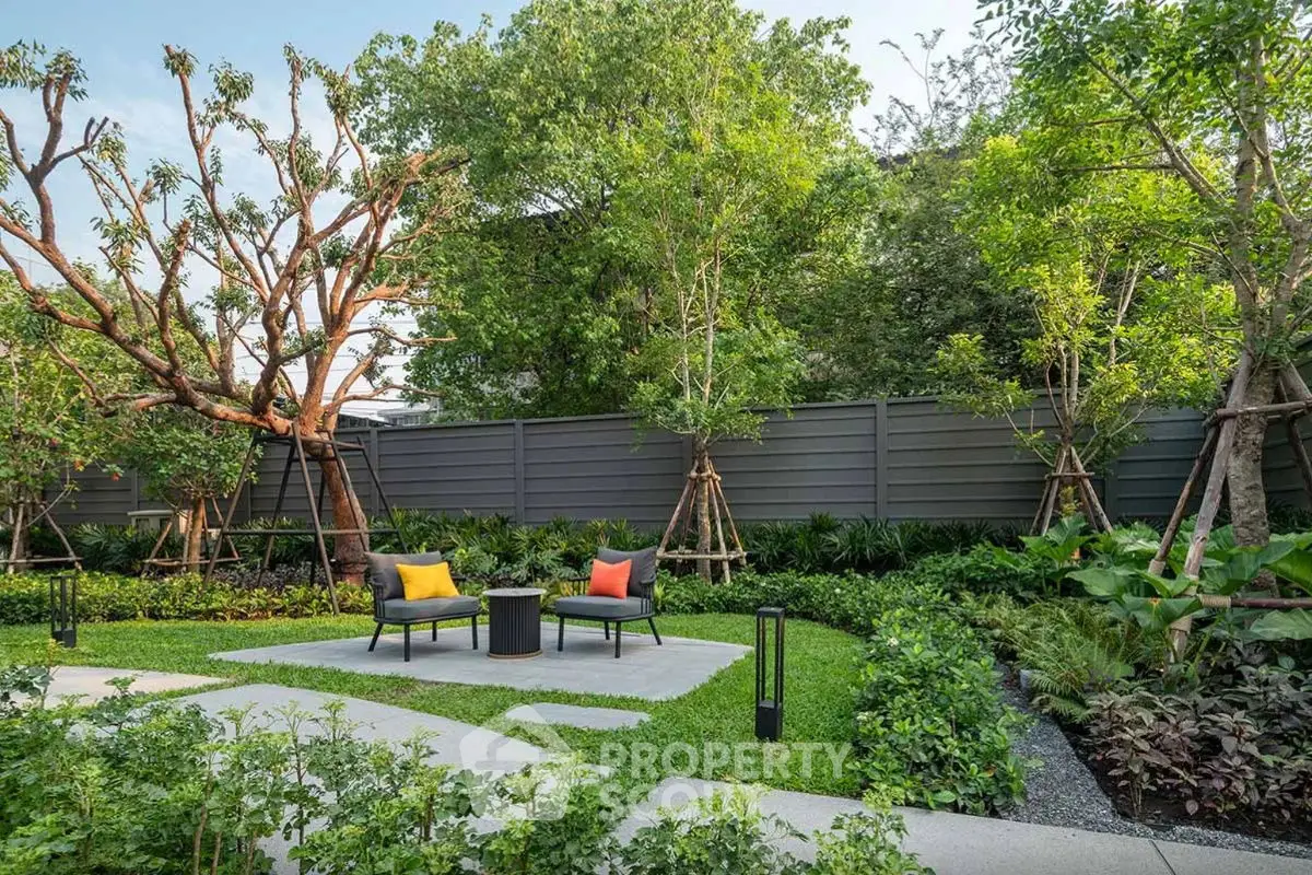 Lush garden with modern outdoor seating and vibrant cushions, perfect for relaxation and entertaining.