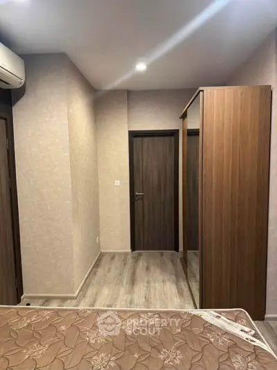 Modern bedroom with wooden wardrobe and air conditioning unit, featuring elegant decor and cozy ambiance.