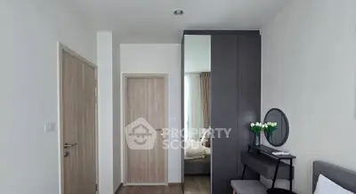 Modern bedroom with sleek furniture and neutral tones, featuring a stylish vanity and mirror.