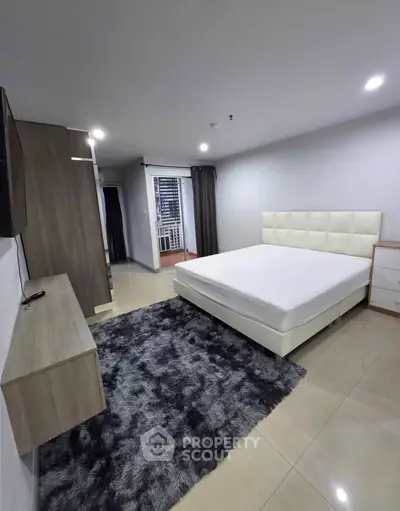 Spacious modern bedroom with minimalist decor and plush carpet