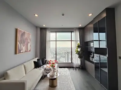 Modern living room with city view, stylish decor, and large windows.