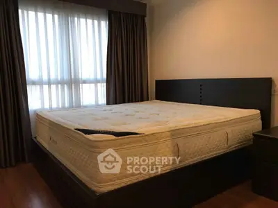 Spacious bedroom with large bed and natural light from window