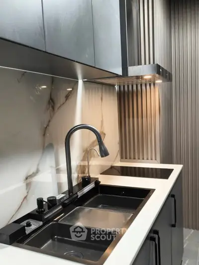 Modern kitchen with sleek black fixtures and marble backsplash, showcasing contemporary design and functionality.