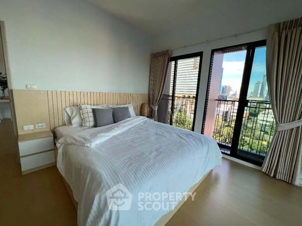 Spacious bedroom with balcony and city view in modern apartment