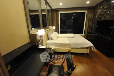 Luxurious bedroom with city view, elegant furnishings, and ambient lighting