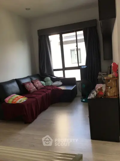 Cozy living room with modern decor and large window for natural light.