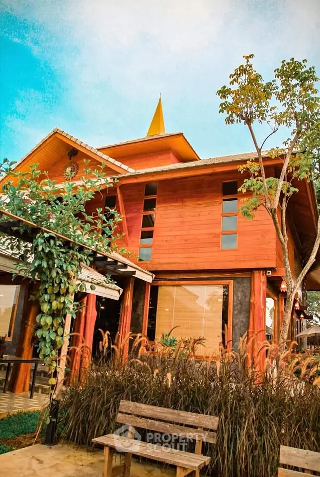 Charming wooden house with lush garden and rustic bench, perfect for nature lovers.