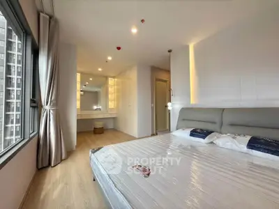 Spacious modern bedroom with large window and elegant decor