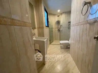 Spacious modern bathroom with elegant tile design and glass shower enclosure.
