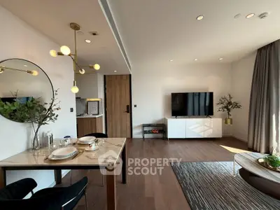Modern living room with stylish decor and open layout, featuring a dining area and large TV.
