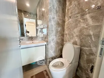 Modern bathroom with marble walls and sleek fixtures in a contemporary apartment.
