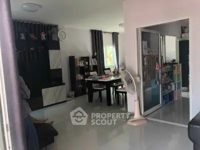 Spacious living room with modern decor and dining area, featuring sleek furniture and ample natural light.