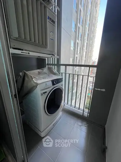 Compact balcony with washing machine in modern high-rise apartment