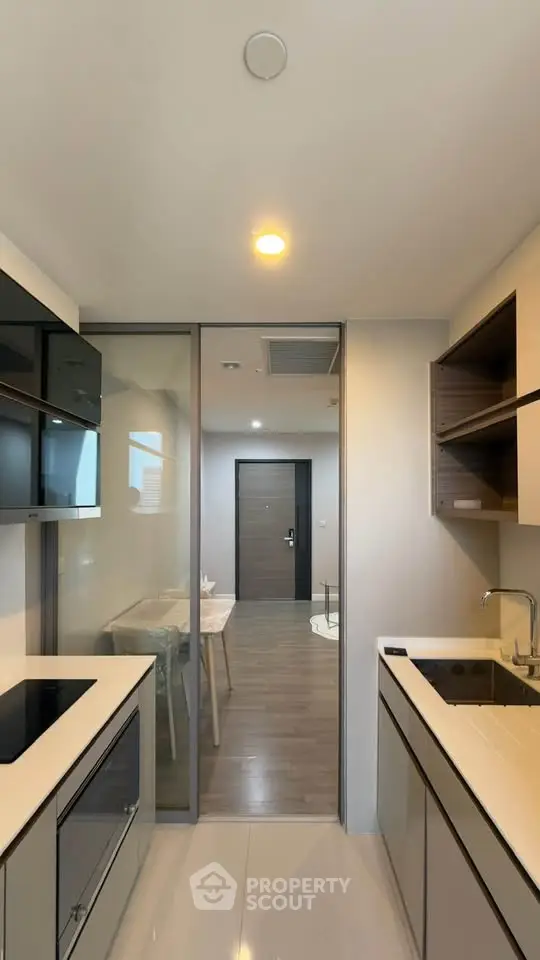 Modern kitchen with sleek design and open layout leading to dining area.