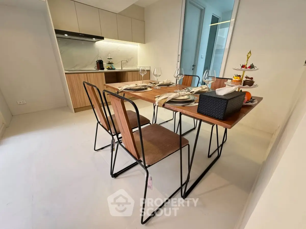 Modern dining area with stylish table and chairs adjacent to a sleek kitchen.