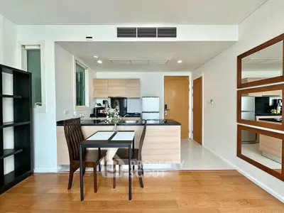 Modern kitchen with dining area featuring sleek wooden cabinets and stylish decor.