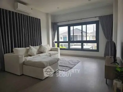 Spacious living room with large windows and modern furnishings in a bright home.