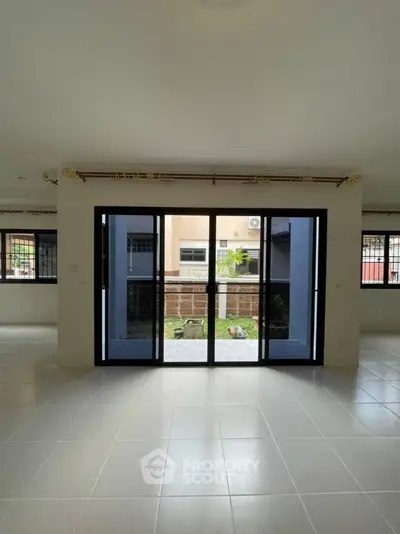 Spacious living room with large sliding glass doors leading to a garden view.