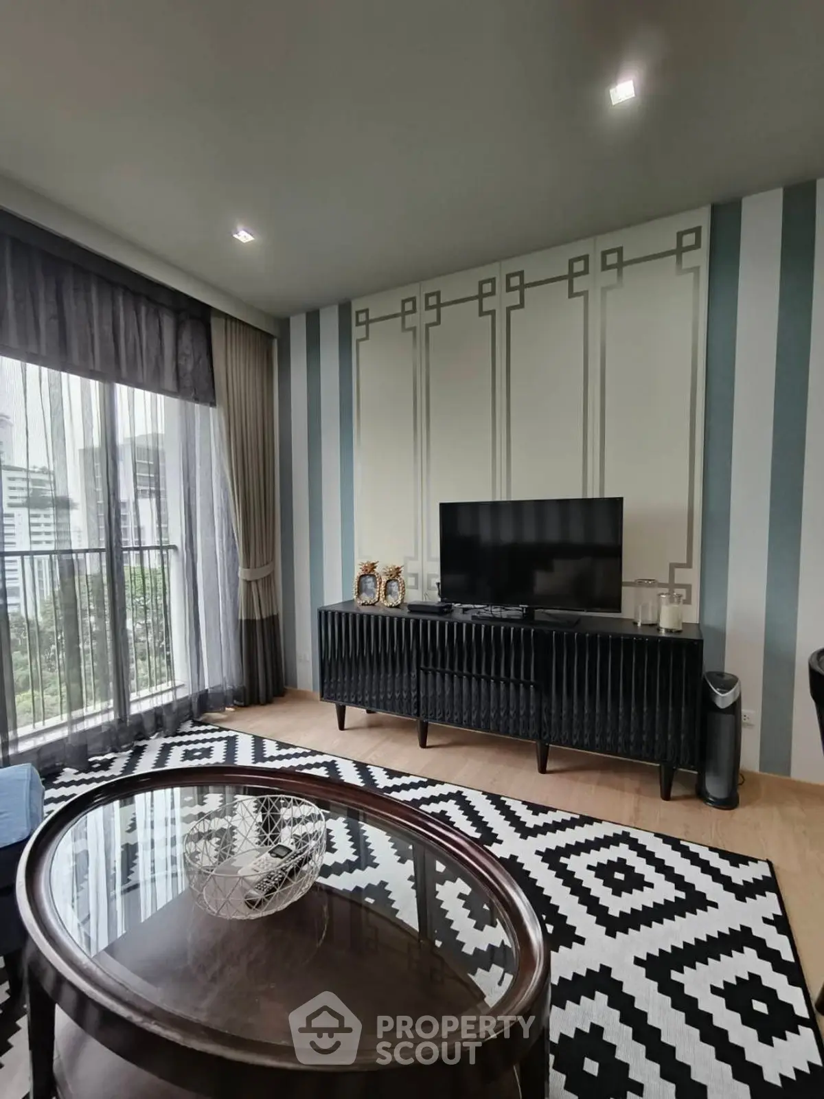 Stylish living room with modern decor and city view from large windows.