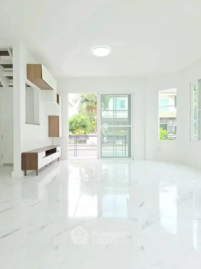 Spacious modern living room with marble flooring and large windows for natural light.
