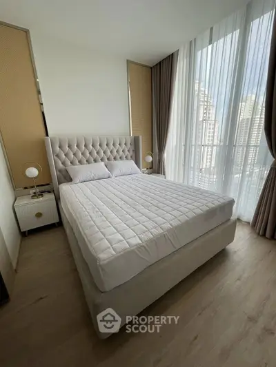 Luxurious bedroom with elegant decor and city view, featuring a plush bed and modern furnishings.