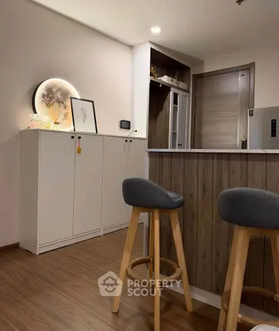 Modern kitchen with stylish bar stools and wooden flooring, perfect for cozy gatherings.