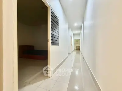 Spacious hallway with glossy tiled floors leading to multiple rooms in a modern apartment.