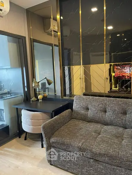 Modern living room with stylish decor and adjacent kitchen area in a contemporary apartment.