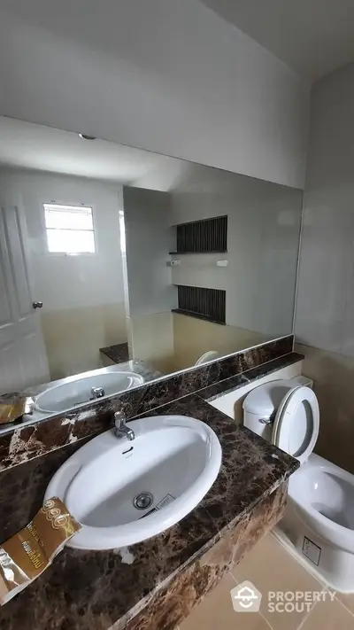 Modern bathroom with marble countertop and large mirror