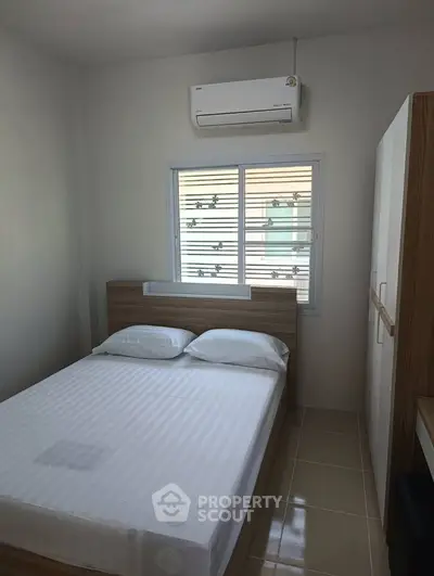 Cozy bedroom with modern air conditioning and ample natural light, perfect for restful nights.